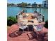 Inviting waterfront dock with comfortable lounge chairs and a fire pit table at 187 175Th Terrace E Dr, Redington Shores, FL 33708