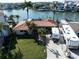 Stunning waterfront home featuring lush landscaping, tile roof, and convenient RV parking on a spacious driveway at 187 175Th Terrace E Dr, Redington Shores, FL 33708