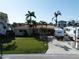 Inviting home features a well-manicured lawn, mature palm trees, and convenient RV parking at 187 175Th Terrace E Dr, Redington Shores, FL 33708
