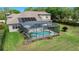 Aerial view of backyard, showing a swimming pool with screen enclosure and well-maintained grassy lawn at 21654 Draycott Way, Land O Lakes, FL 34637