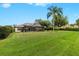 Spacious backyard featuring a well-maintained lawn, lush landscaping, and a screened patio, perfect for outdoor enjoyment at 21654 Draycott Way, Land O Lakes, FL 34637