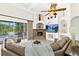 Inviting living room with a stone fireplace, vaulted ceilings, a ceiling fan, and a view of the screened in pool at 21654 Draycott Way, Land O Lakes, FL 34637