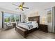 A beautifully staged main bedroom with dark wood accents, a ceiling fan, and natural light from the large window at 21654 Draycott Way, Land O Lakes, FL 34637