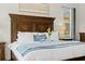 Close up of the main bedroom shows the luxurious bedding, furnishings, and natural light from the window at 21654 Draycott Way, Land O Lakes, FL 34637