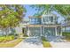 Inviting townhome featuring a two-car garage, neutral paint, and mature trees providing shade at 2211 Kings Palace Dr, Riverview, FL 33578