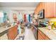 The kitchen features tile flooring, wood cabinets, stainless steel appliances, and granite countertops at 2211 Kings Palace Dr, Riverview, FL 33578
