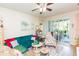 A cozy living room featuring a floral print chair, a teal couch, and sliding glass doors to the patio at 2211 Kings Palace Dr, Riverview, FL 33578