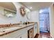 Bathroom featuring dual sinks, granite countertops, and decorative mirrors and wreath at 225 Country Club Dr # 1104, Largo, FL 33771