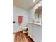 Bathroom with white vanity, round mirror, wood flooring, and decorative hand towel at 225 Country Club Dr # 1104, Largo, FL 33771