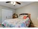 Cozy bedroom featuring ceiling fan, closet, and bed with patterned comforter in neutral tones at 225 Country Club Dr # 1104, Largo, FL 33771
