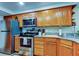 Kitchen showcasing oak cabinets, granite countertops, and stainless steel appliances at 225 Country Club Dr # 1104, Largo, FL 33771