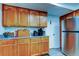 Kitchen area features light wood cabinetry, granite countertops, and stainless steel refrigerator at 225 Country Club Dr # 1104, Largo, FL 33771