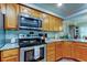 Well-lit kitchen boasts stainless steel appliances, granite countertops, and light wood cabinetry at 225 Country Club Dr # 1104, Largo, FL 33771