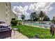 Relax on this private patio overlooking the green lawn and community pool beyond a white fence at 225 Country Club Dr # 1104, Largo, FL 33771