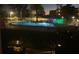 Inviting community pool at dusk surrounded by mature landscaping and secure fencing at 225 Country Club Dr # 1104, Largo, FL 33771