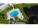 Aerial view of community pool with lounge chairs, sun umbrellas, and nearby waterway at 225 Country Club Dr # 1104, Largo, FL 33771
