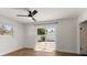 Bright bedroom with wood floors and a sliding glass door that leads out to a private backyard patio at 331 Barbara Cir, Belleair, FL 33756