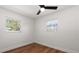 Bright bedroom features wood floors, white walls, a ceiling fan, and two windows at 331 Barbara Cir, Belleair, FL 33756
