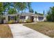 Home exterior showcases well-manicured lawn, black shutters, and modern front door at 331 Barbara Cir, Belleair, FL 33756