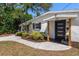 Inviting home entrance with modern black door, new landscaping, and a welcoming walkway at 331 Barbara Cir, Belleair, FL 33756