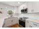 The kitchen boasts white cabinets, quartz counters, and stainless steel appliances at 331 Barbara Cir, Belleair, FL 33756