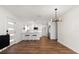 Open-concept living and kitchen area featuring hardwood flooring, modern light fixture, and breakfast bar at 331 Barbara Cir, Belleair, FL 33756