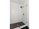 Contemporary glass shower boasts white subway tile and sleek black fixtures over a hexagon tile base at 331 Barbara Cir, Belleair, FL 33756