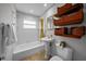 Bathroom features a tub with shower, pedestal sink, and woven storage baskets at 3409 W El Prado Blvd, Tampa, FL 33629