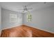 Bright bedroom featuring hardwood floors, a ceiling fan, and two windows allowing ample natural light at 3409 W El Prado Blvd, Tampa, FL 33629