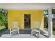 Charming covered entrance with rocking chairs and a view into the updated kitchen at 3409 W El Prado Blvd, Tampa, FL 33629