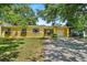 Charming yellow single-story home with well-manicured lawn and mature trees. Includes a one car garage at 3409 W El Prado Blvd, Tampa, FL 33629
