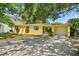 Charming home with a sunny yellow exterior, a well-manicured lawn and private driveway at 3409 W El Prado Blvd, Tampa, FL 33629