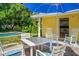 Outdoor patio with dining table, seating, and a blue umbrella, with view of the pool at 3409 W El Prado Blvd, Tampa, FL 33629