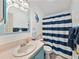 Bathroom featuring a blue vanity with a striped shower curtain at 35026 Colony Hills Dr, Zephyrhills, FL 33541