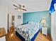Bedroom with blue accent wall, hardwood floors, and ensuite bathroom at 35026 Colony Hills Dr, Zephyrhills, FL 33541