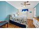 Bedroom with blue accent wall, hardwood floors, and nautical themed bedspread at 35026 Colony Hills Dr, Zephyrhills, FL 33541