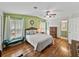 Comfortable bedroom featuring hardwood floors, green walls and large windows at 35026 Colony Hills Dr, Zephyrhills, FL 33541