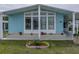 Close-up of a light blue home showcasing detailed landscaping and charming curb appeal at 35026 Colony Hills Dr, Zephyrhills, FL 33541