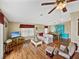 Open-concept living room with elegant furnishings, a ceiling fan, and seamless access to the dining area at 35026 Colony Hills Dr, Zephyrhills, FL 33541