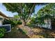 Spacious backyard with large tree, green grass, a shed, and mature landscaping at 3815 Bowen St, New Port Richey, FL 34652