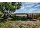 Landscaped backyard featuring a screened patio, large tree, and well-maintained lawn at 3815 Bowen St, New Port Richey, FL 34652