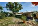 Beautiful backyard featuring a large tree, an enclosed porch, and lush landscaping, perfect for relaxation and outdoor activities at 3815 Bowen St, New Port Richey, FL 34652