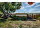 A shady backyard featuring an enclosed porch, mature trees, and a well-maintained lawn, offering serene outdoor living at 3815 Bowen St, New Port Richey, FL 34652