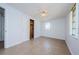 A bright bedroom with white walls, a closet with exposed contents, a window and tile floors at 3815 Bowen St, New Port Richey, FL 34652