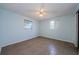 An empty bedroom with light blue walls, two windows, a ceiling fan and tile floors at 3815 Bowen St, New Port Richey, FL 34652