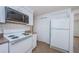 Functional kitchen with white cabinets and appliances, tile backsplash, complemented by durable and stylish tile flooring at 3815 Bowen St, New Port Richey, FL 34652