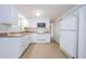 Functional kitchen with white cabinetry, essential appliances, and durable tile flooring, blending practicality with simplicity at 3815 Bowen St, New Port Richey, FL 34652