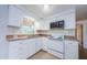 A kitchen featuring white cabinets, laminate countertops and tile flooring with an oven and microwave at 3815 Bowen St, New Port Richey, FL 34652