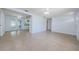 A large living room with white walls, tile floors and connecting access to other rooms at 3815 Bowen St, New Port Richey, FL 34652