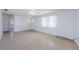 An empty living room with white walls, tile floors, a ceiling fan and large windows at 3815 Bowen St, New Port Richey, FL 34652